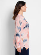 Pink waffle-stitch V-neck sweater with abstract patterns of navy, light blue, and orange brushstrokes.