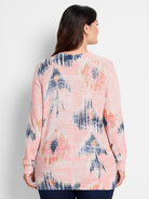 Light pink waffle stitch sweater with an abstract pattern in dark blue, light blue, and orange.