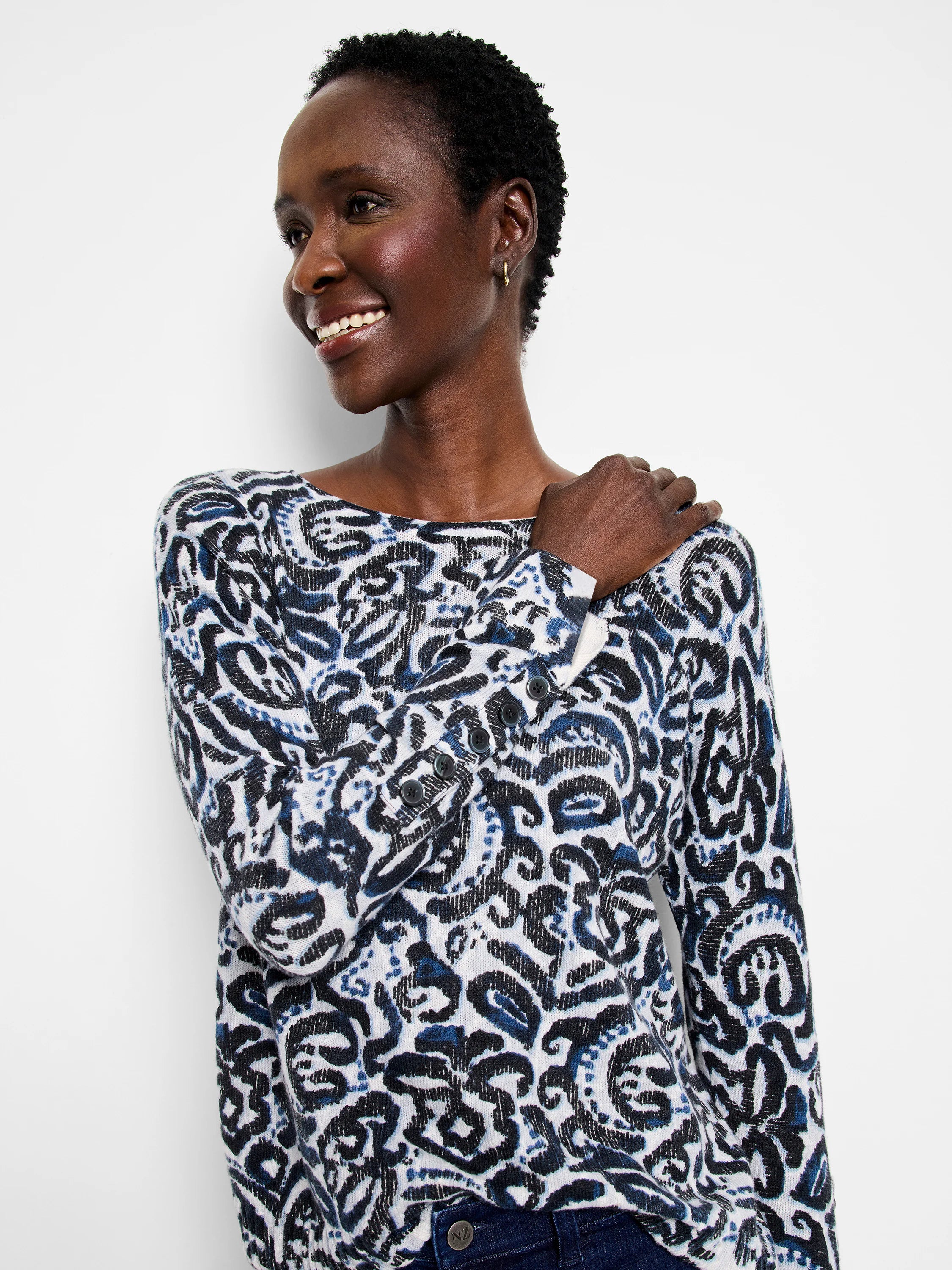 White sweater with dark blue & black tossed paisley pattern, boat neck, long sleeves.