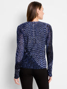 Back of indigo cardigan with a knit pattern of white and light blue dashes on a dark blue background. Long-sleeved.
