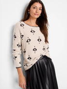 Cream knit sweater with black abstract geometric print. Features black rib-knit trim on neckline, cuffs, and hem.