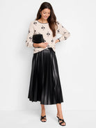 Cream knit sweater with black geometric pattern and black scalloped trim.