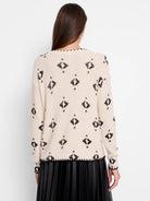Off-white waffle knit sweater with black diamond & dot print, black trim on edges.