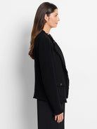 Black textured knit jacket with fringe along front, cuffs, and hem. Features one buttoned flap pocket.