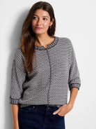 Navy and cream tuck stitch sweater with textured pattern, round neck, 3/4 sleeves, and striped ribbed trim.