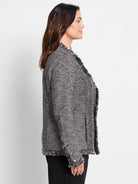 Black & white mixed knit jacket with fringe trim on open front, cuffs, and hem. Features chevron knit panels.