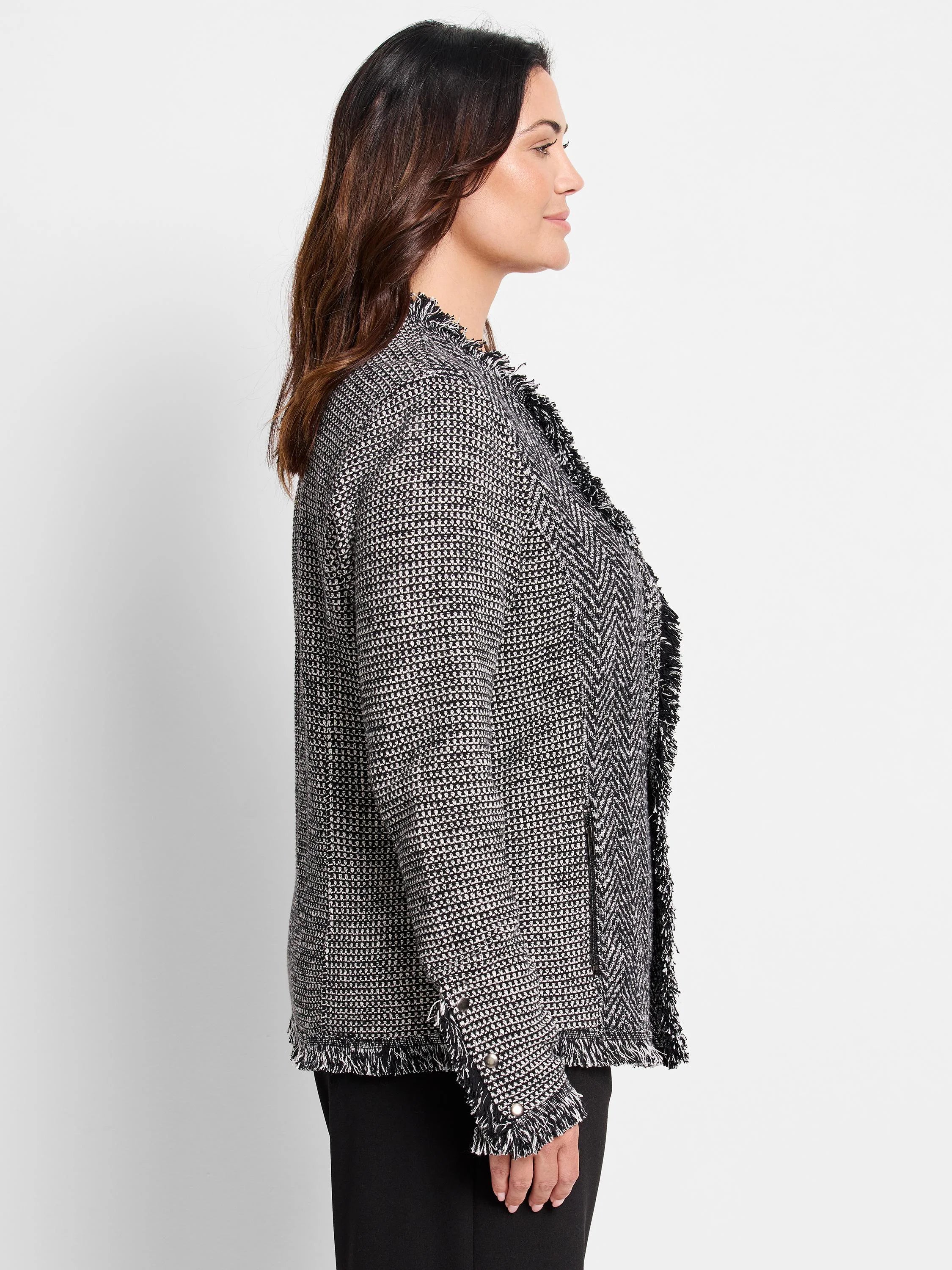 Black & white mixed knit jacket with fringe trim on open front, cuffs, and hem. Features chevron knit panels.