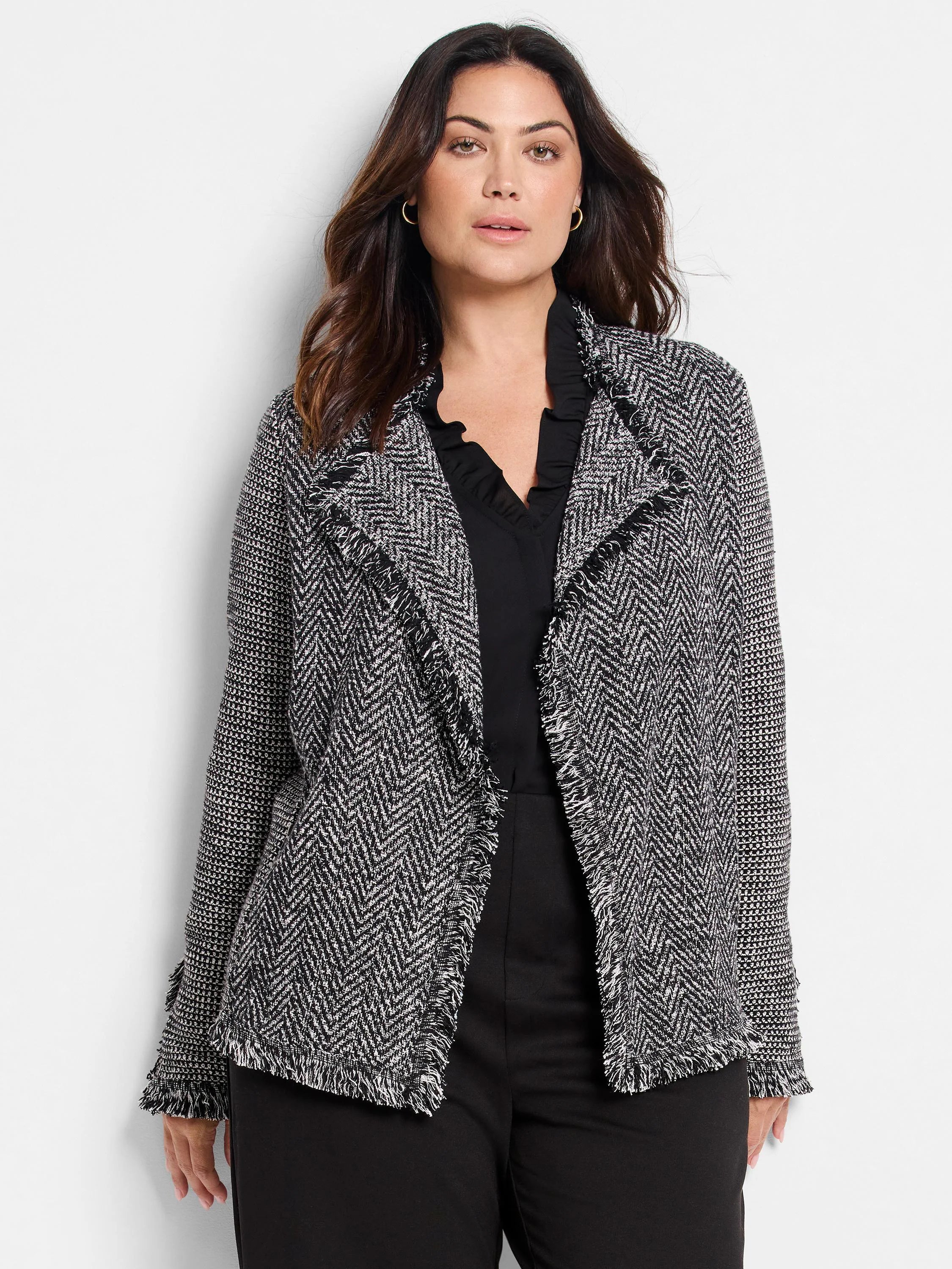 Black & white mix knit jacket with fringe on the lapels, hem, and cuffs.