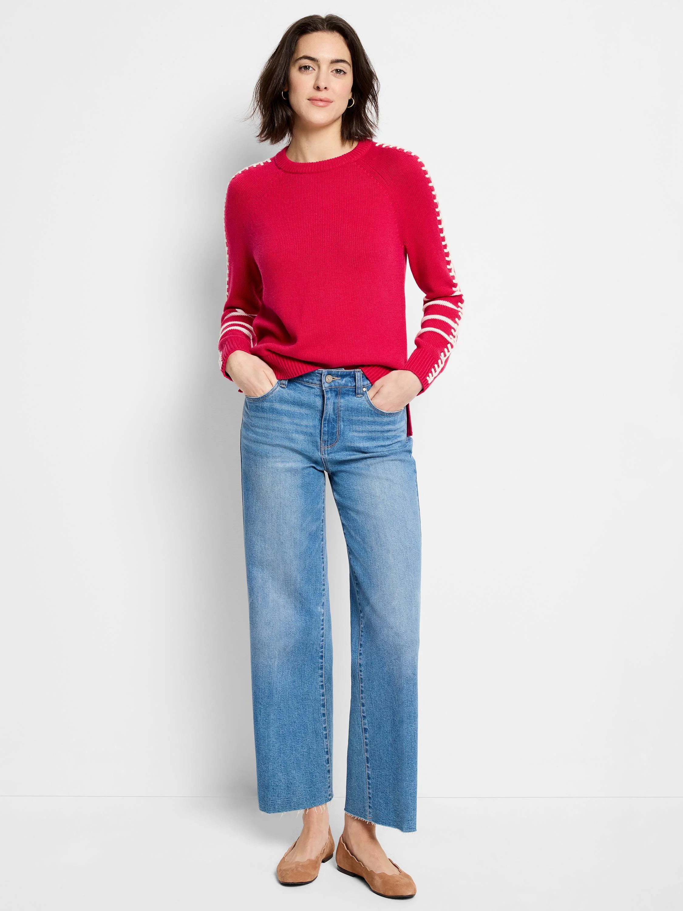 Bright pink sweater with white dashed stitching along raglan sleeves and cuffs.