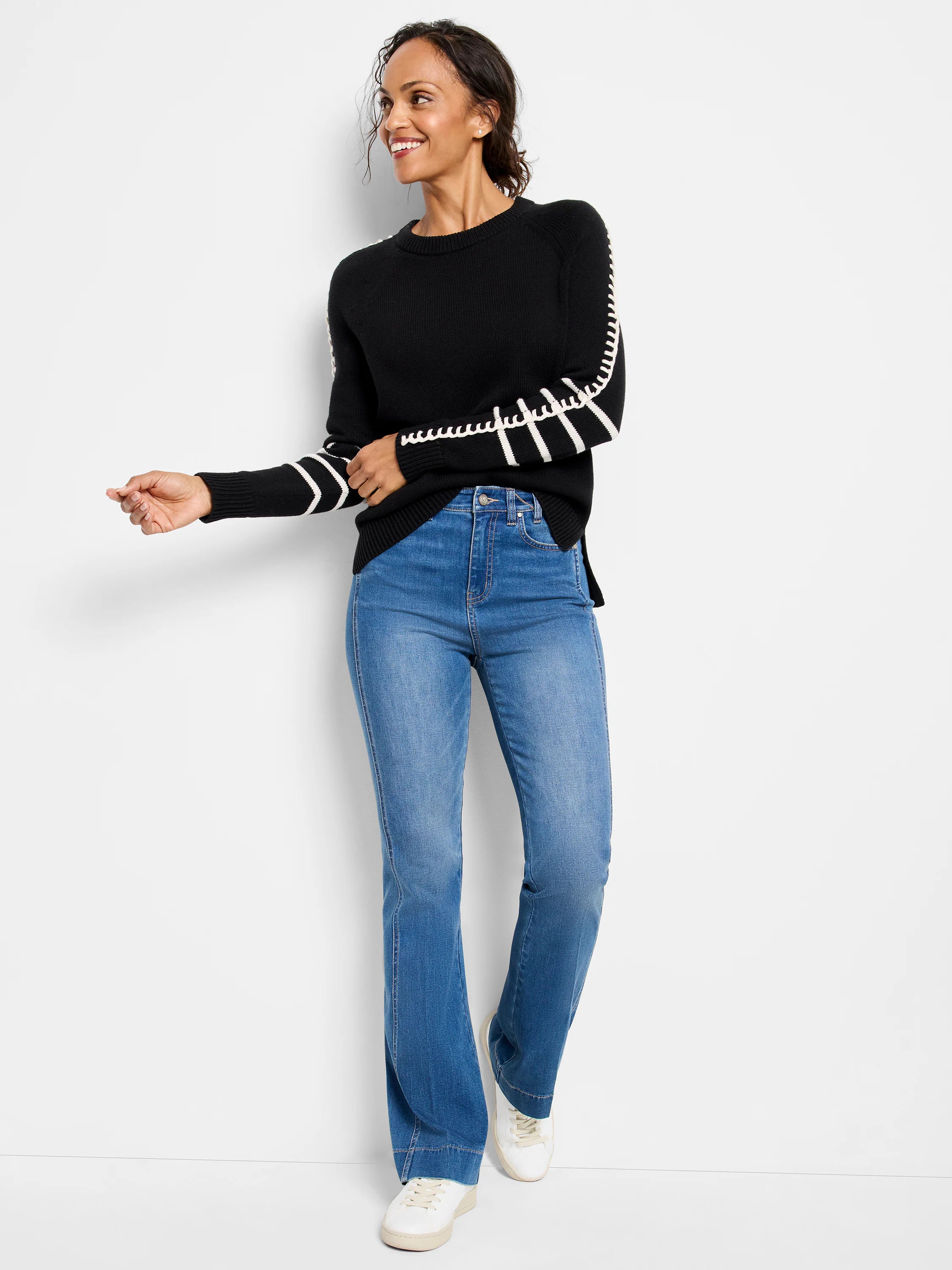 Black sweater with white ladder-like patterns on sleeves, ribbed crew neck, cuffs, and hem.