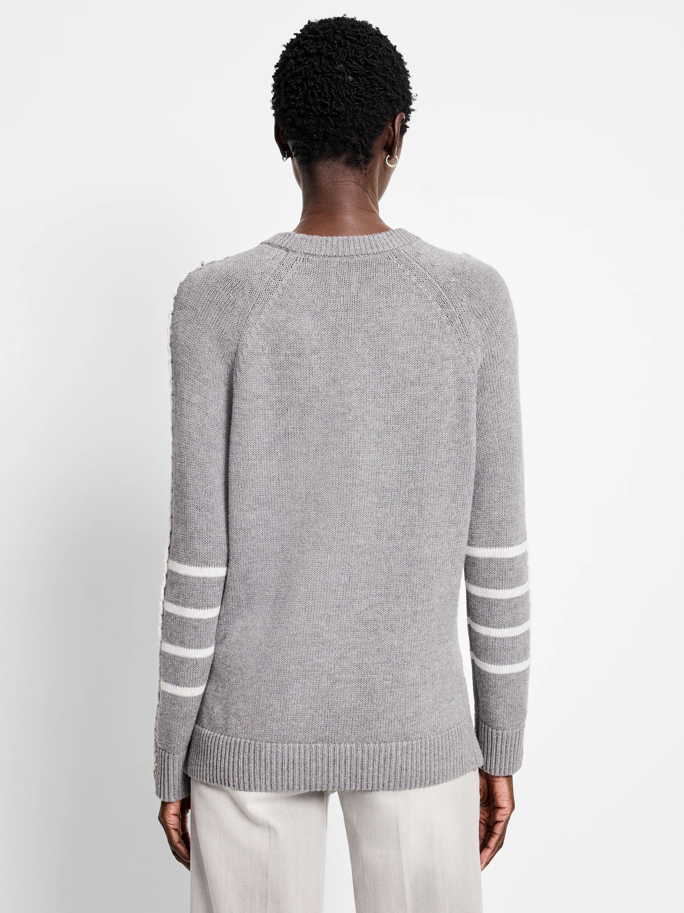 Back of a grey crew neck sweater with white triple stripes on both sleeves.