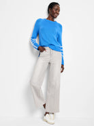 Vibrant blue sweater with prominent white stitched stripes on the upper arms. Features a ribbed knit texture.