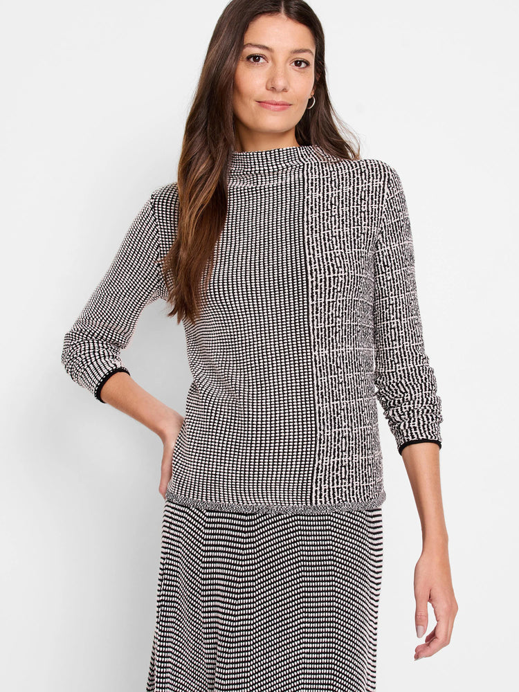 Pixel knit sweater: black and white mock neck with 3/4 sleeves. Features a pattern of small dots and vertical striped panels.