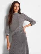 Black and blush pink patterned mock neck, three-quarter sleeve sweater.  Subtle shimmer at hem.