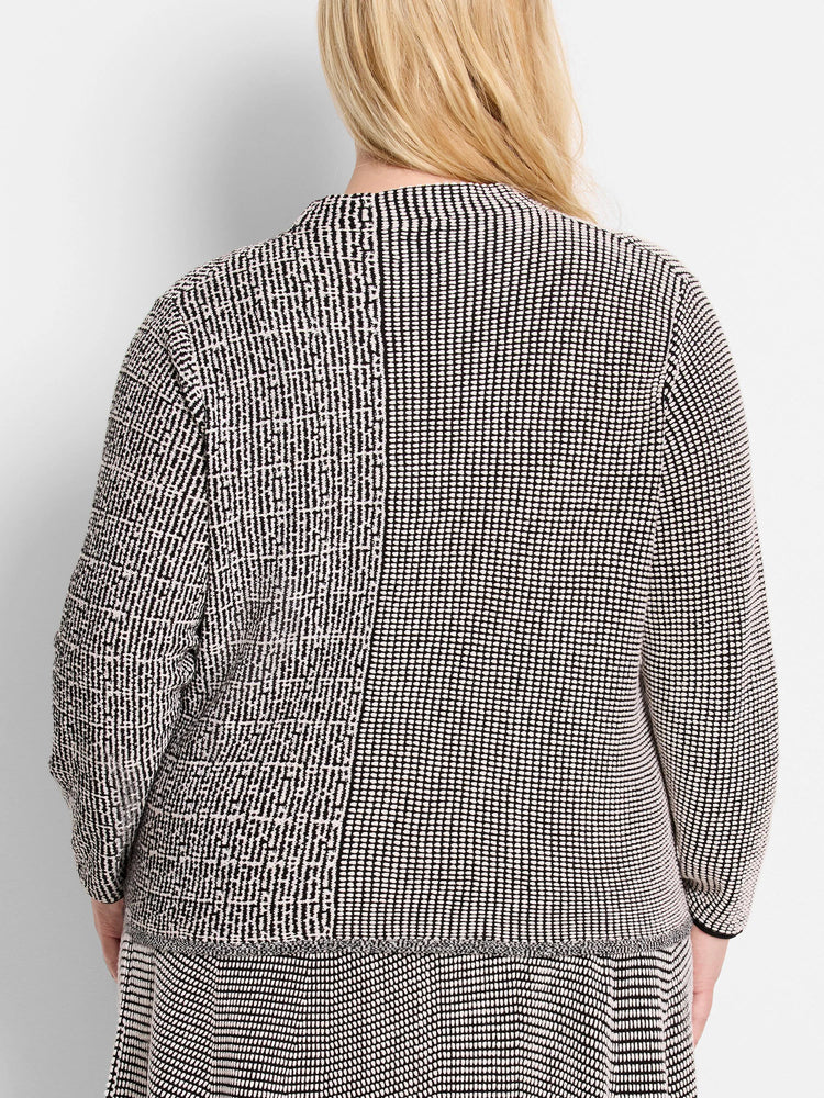 Black and off-white pixel knit sweater showing two distinct patterns: uniform dots and irregular blocks separated by a seam.