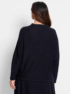 Dark navy blue waffle-knit sweater.  Long sleeves, crew neck.  Back view shown.