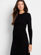 Black ribbed knit sweater tee with long sleeves and a pleated hem.