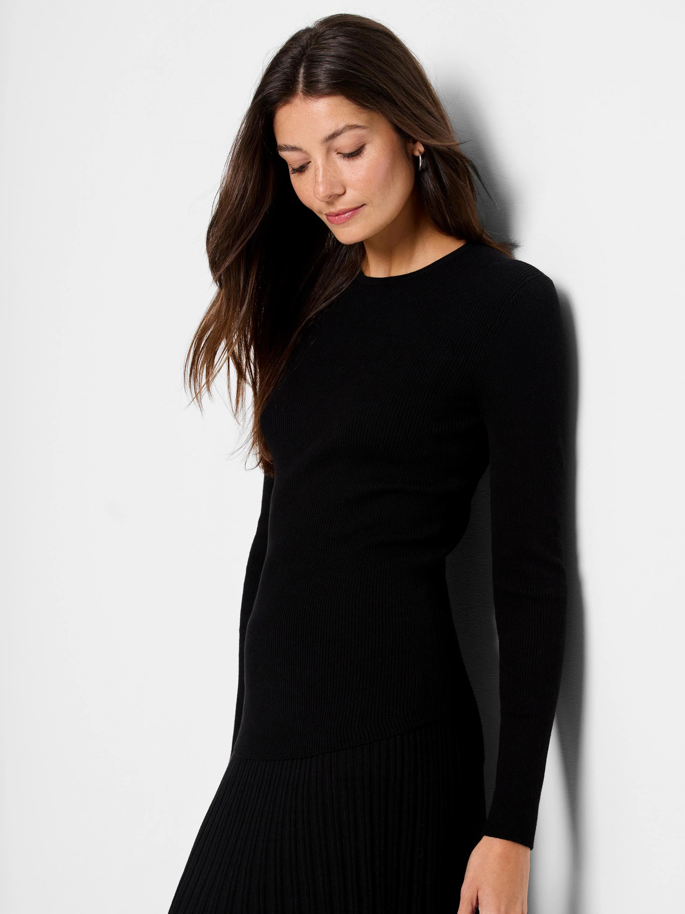 Black ribbed sweater tee with long sleeves and a pleated hem.