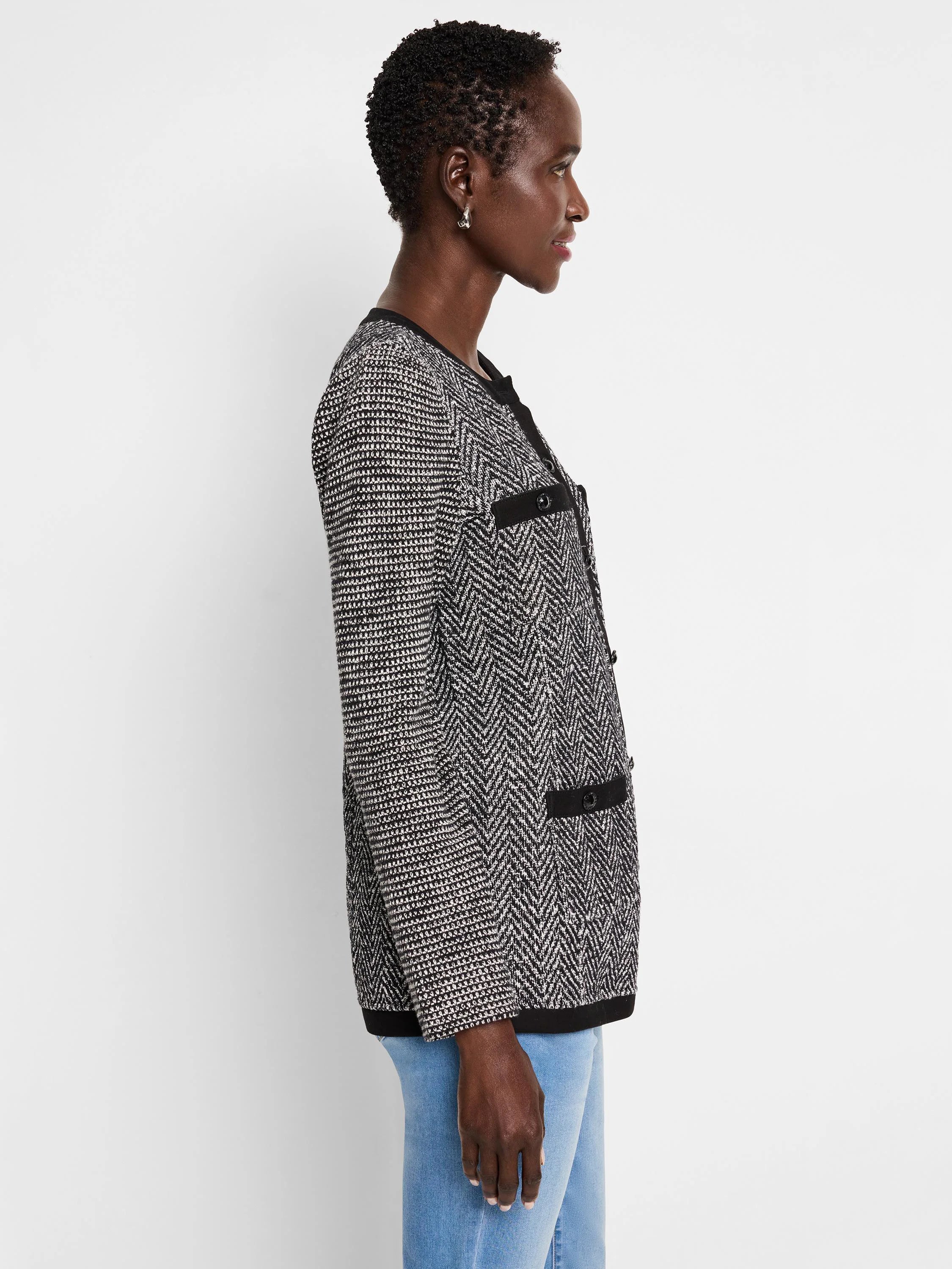 Black and white herringbone knit jacket with black buttons and trim.  Side profile view.