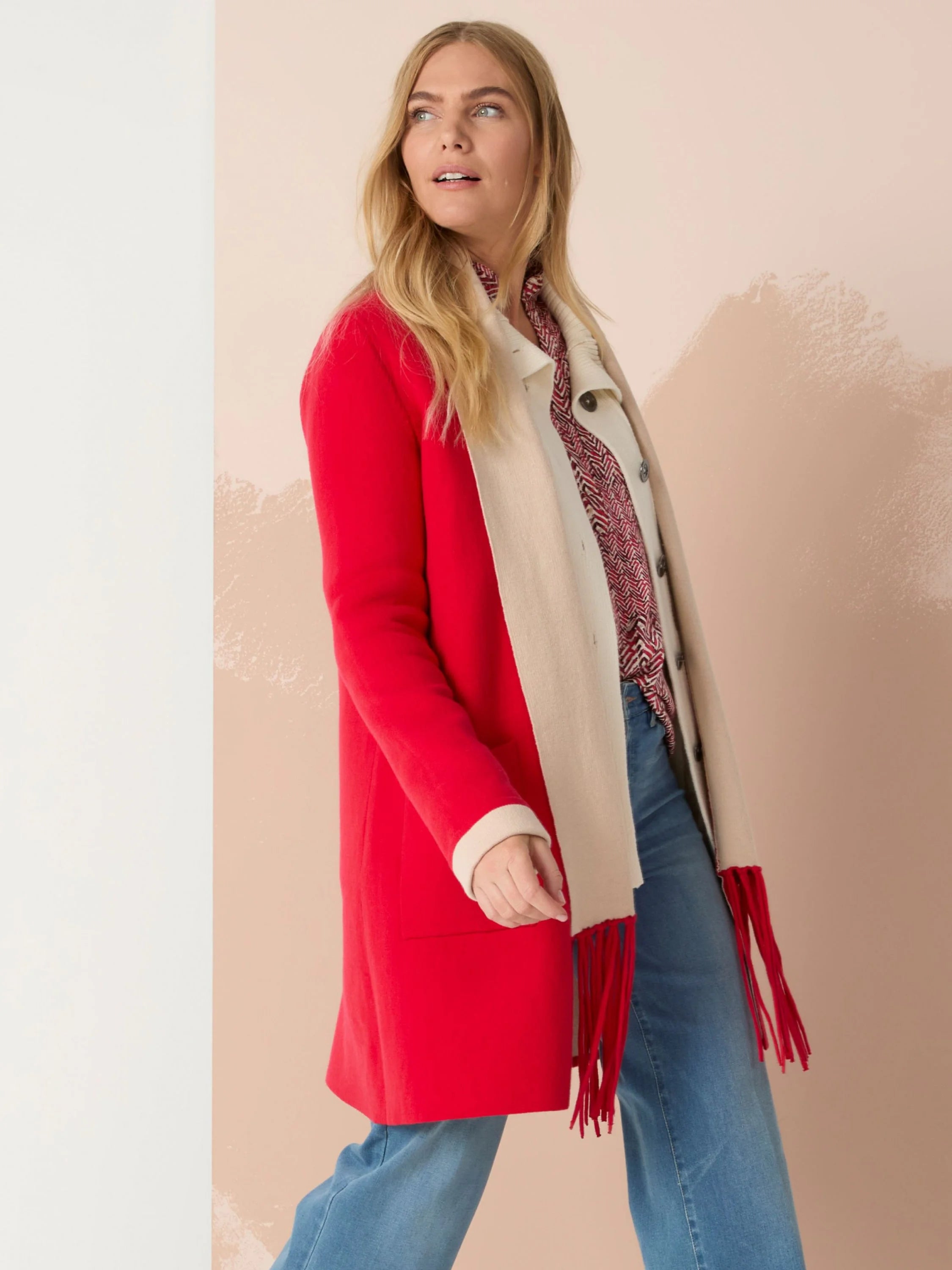 Reversible jacket; one side red, the other cream.  Features long fringe in red.
