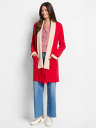 Red reversible jacket with cream/beige interior;  long sleeves, pockets, and fringed trim.