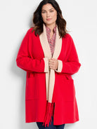 Red jacket with beige collar and cuffs, and a red fringe detail.  Open front, hip length, patch pockets.