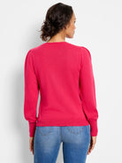Bright pink long-sleeve sweater with puffed shoulders, ribbed cuffs, and hem.