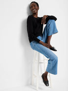 Black crewneck sweater with full sleeves that gather at ribbed cuffs.