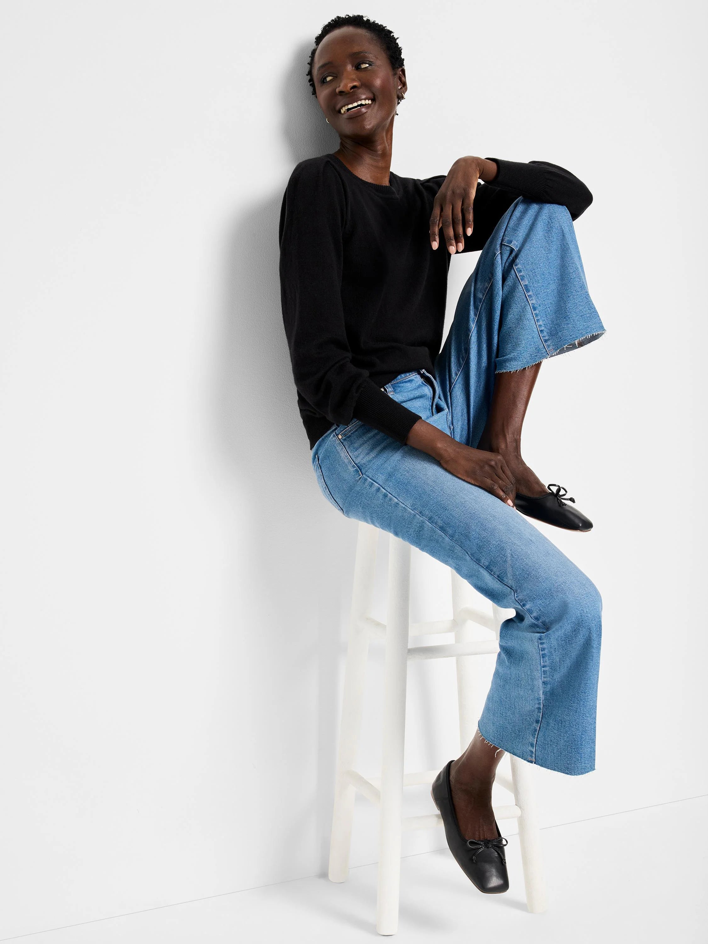 Black crewneck sweater with full sleeves that gather at ribbed cuffs.