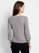 Grey fine knit sweater with puff sleeves, ribbed crew neck, cuffs, and hem.