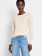 Light beige crewneck sweater with gathered puff shoulders on its long sleeves and ribbed cuffs.