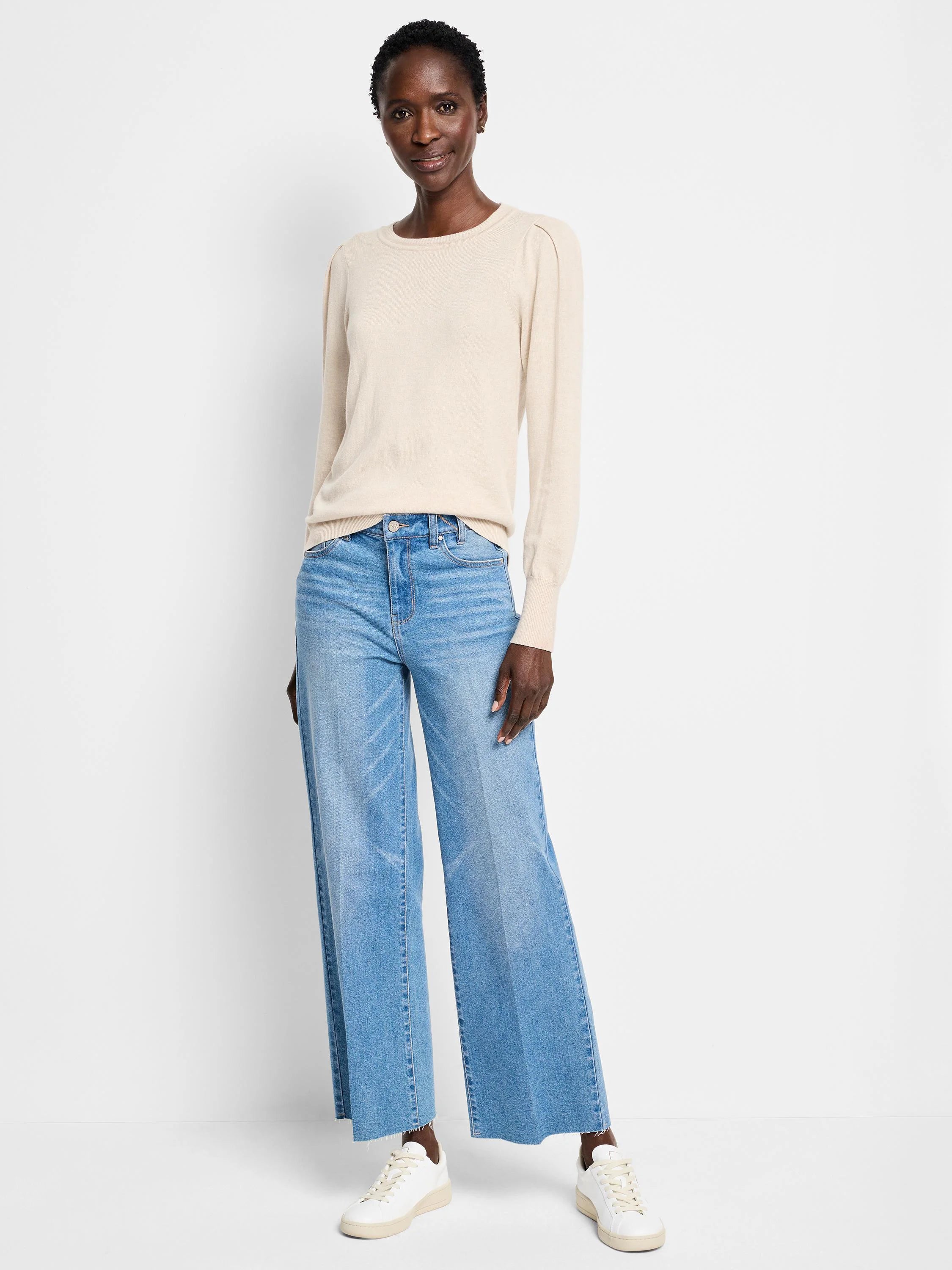 Pale beige long-sleeve sweater with a round neck and subtle puffed shoulders.