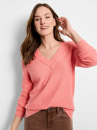 Coral pink waffle stitch V-neck sweater with ribbed neckline and cuffs.