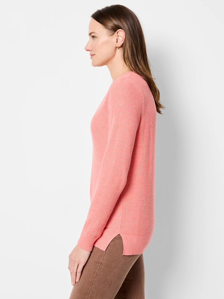 Pink waffle stitch V-neck sweater on a model, featuring ribbed cuffs, hem, and side slits.