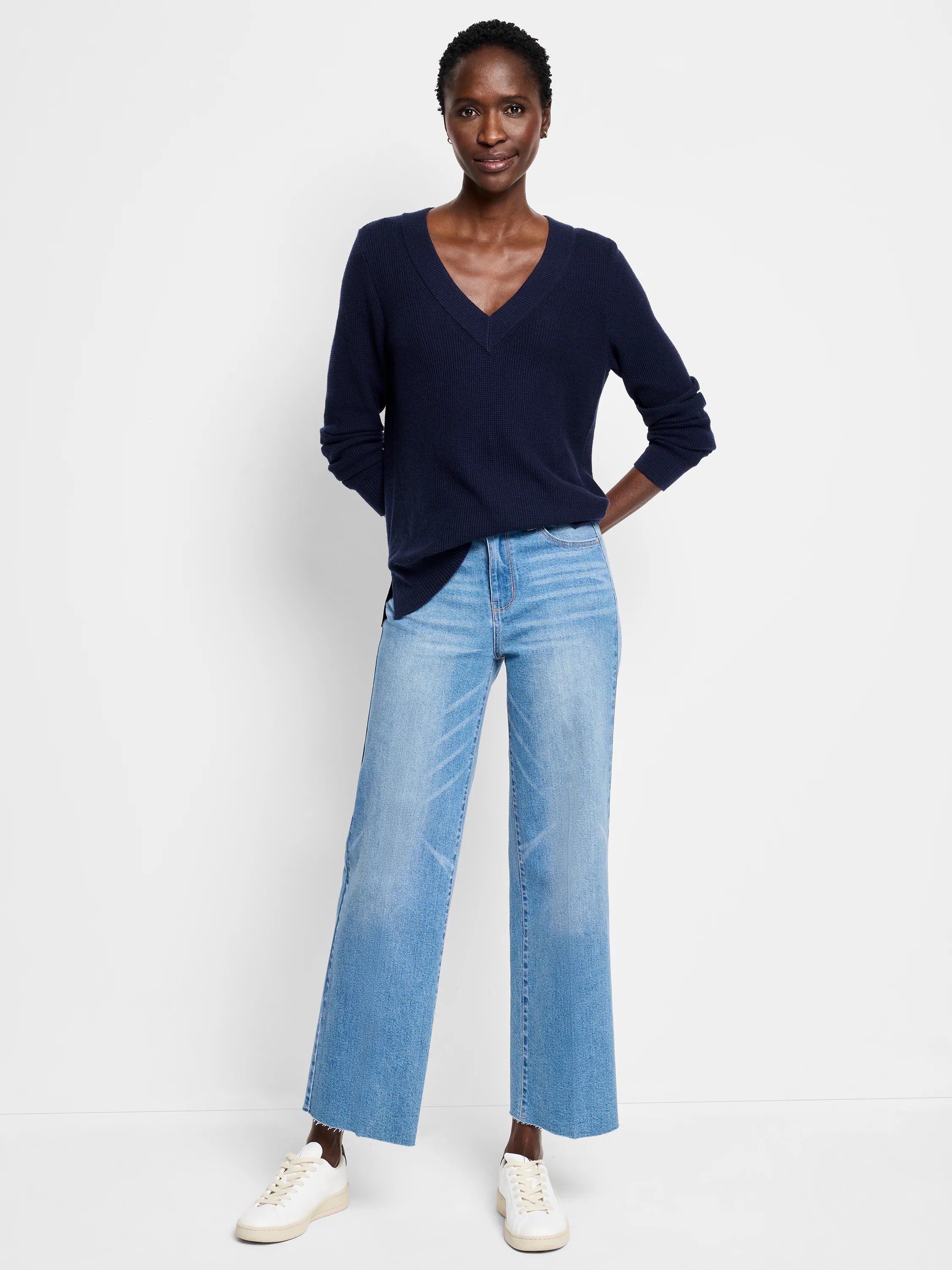 Navy blue V-neck sweater with a waffle stitch texture. Relaxed fit, long sleeves.