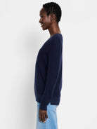 Navy blue waffle stitch V-neck sweater on a model in profile.