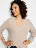 Oatmeal V-neck sweater with waffle knit texture. Features long sleeves and ribbed cuffs.