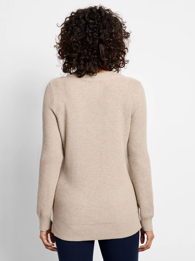 Beige waffle-stitch sweater, back view on model. Features ribbed neck, cuffs, and hem.