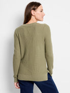 Muted olive green waffle knit V-neck sweater with long sleeves, ribbed cuffs, and a hem with side slits.