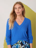 Vibrant blue waffle-stitch V-neck sweater, modeled, showing its textured knit.