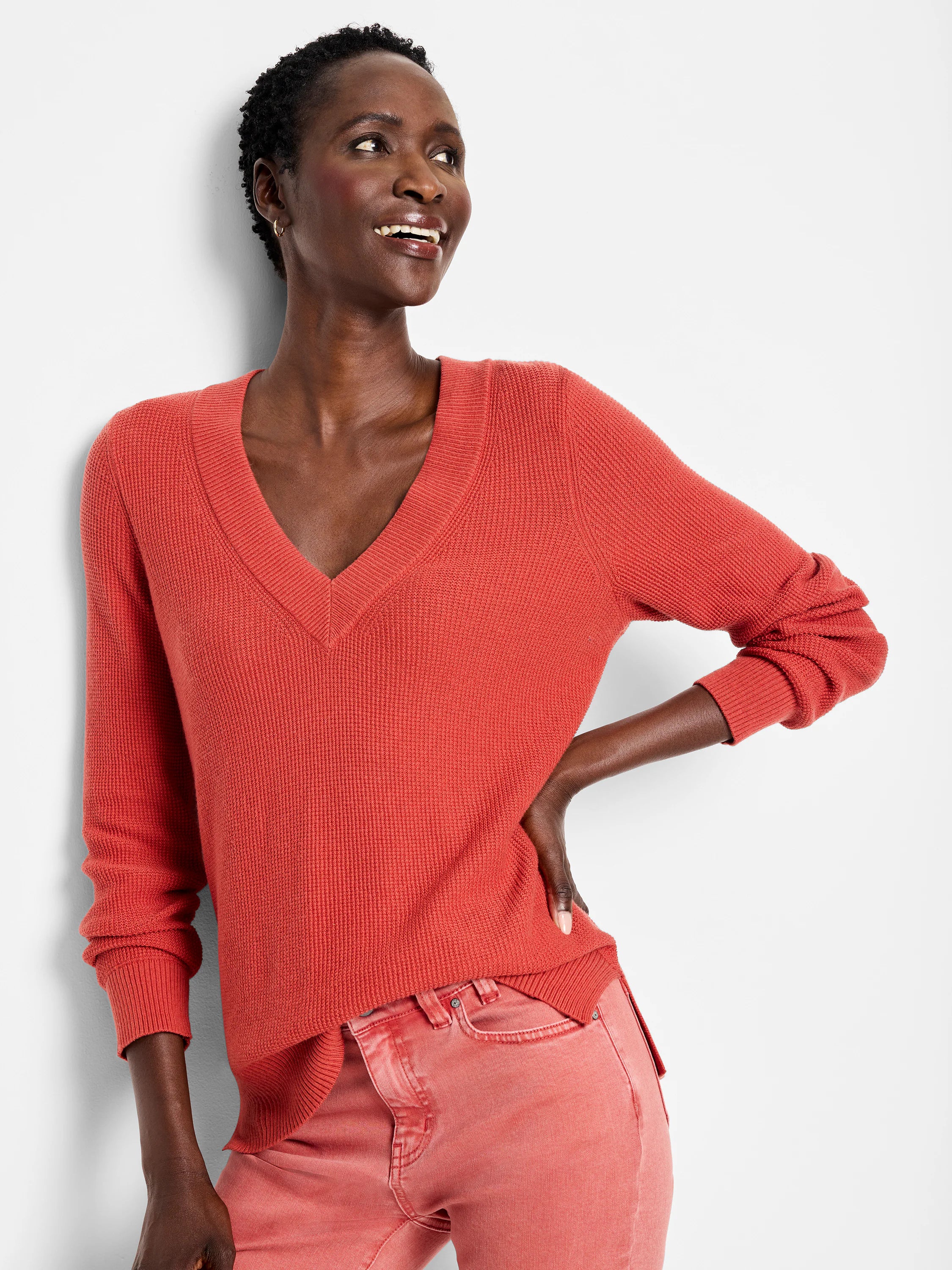 Rust V-neck sweater with a waffle stitch texture, featuring ribbed trim on the neckline, cuffs, and hem.