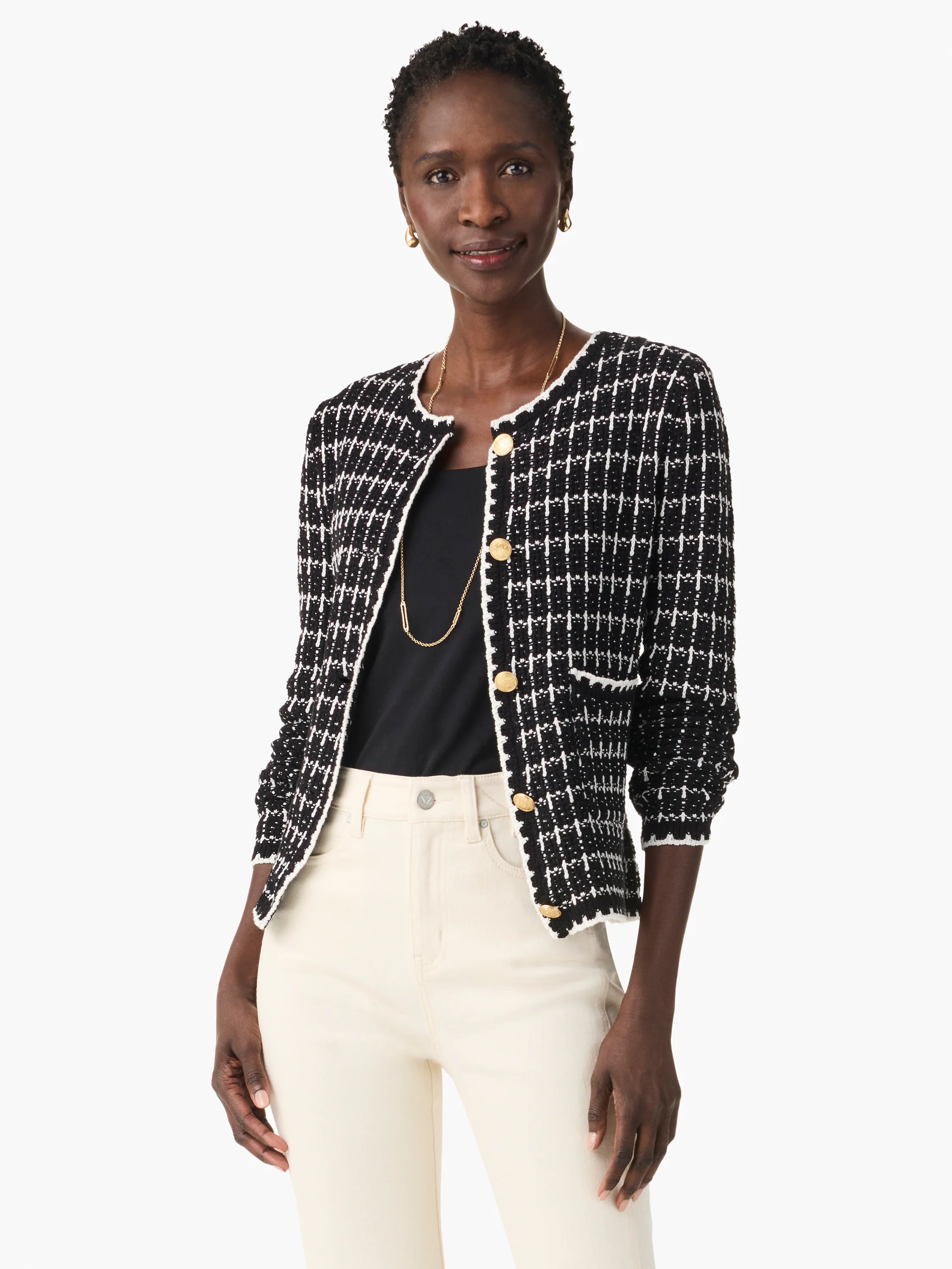 Black and white tweed jacket with gold buttons, elbow-length sleeves, and a patch pocket.