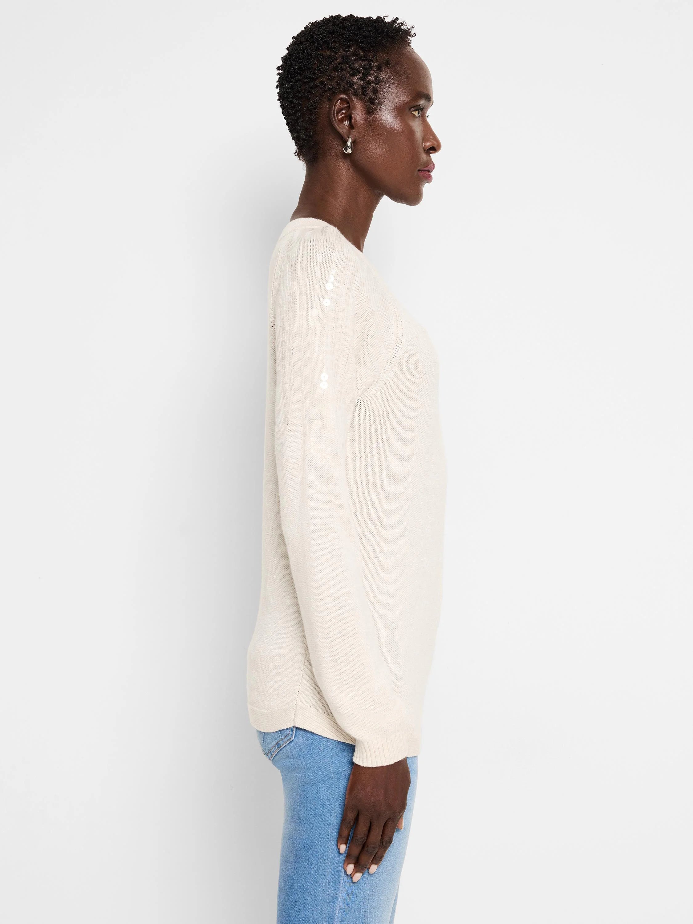 Off-white knit sweater with subtle, light-colored sequins on one sleeve.  Long sleeves, crew neck.