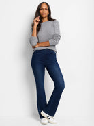 Gray sweater with subtle silver sequins on the shoulders.  Model wears dark wash jeans and white sneakers.