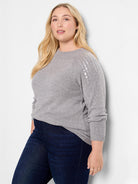 Gray sweater with long sleeves and silver sequins on the upper arms.  Crew neck.