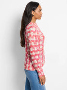 Pink and cream waffle-knit sweater with a textured, abstract pattern. Long sleeves, mock neck.