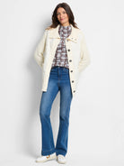 Off-white quilted puffer jacket with cream-colored knit sleeves and button front.