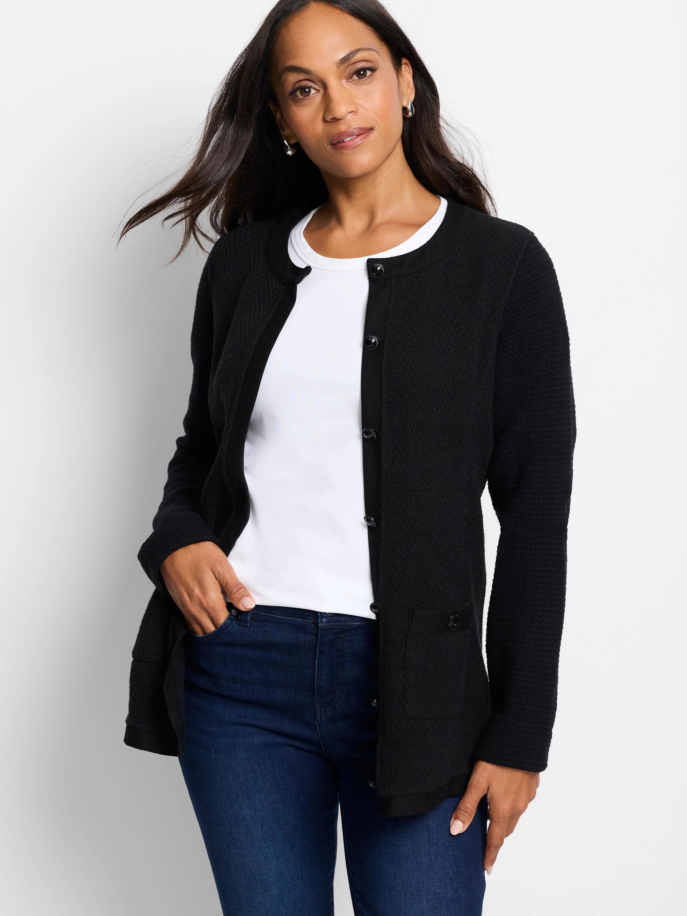Black knit jacket with textured weave, dark buttons, and small pockets.  Features a round neckline and slightly longer...