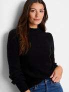 Black waffle-knit sweater. Mock neck, long sleeves, textured fabric.