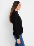 Black waffle-knit sweater, mock neck, long sleeves, and fitted.